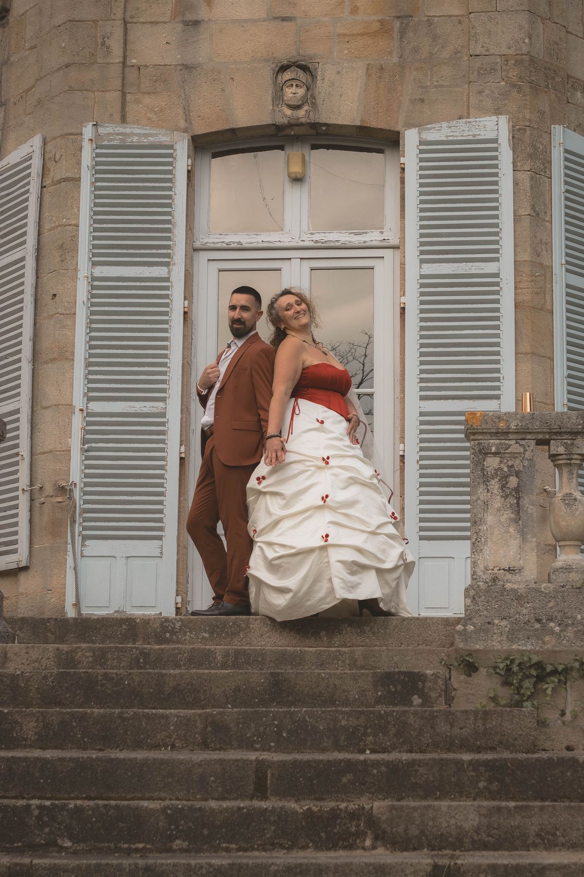Jeunes mariés dos à dos sur les marches d'un château